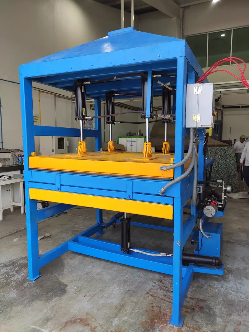 Prensa hidráulica azul y amarilla para fabricar tabla de plástico reciclado, vista frontal