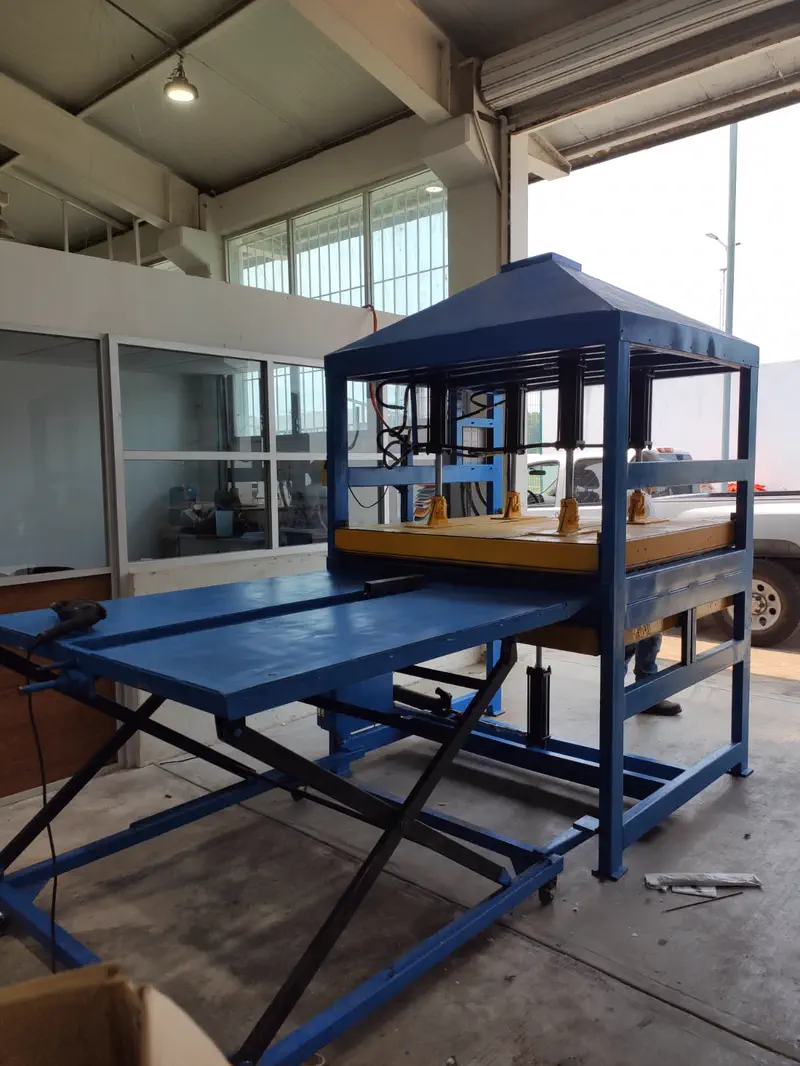 Equipo de prensado de plástico reciclado con mesa desplegada en el taller