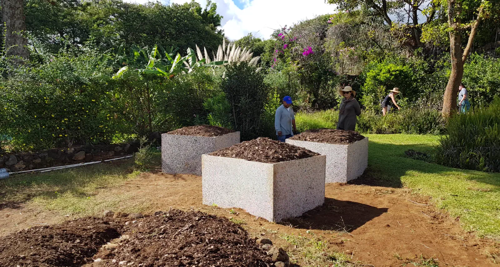 Composteras de plástico reciclado instaladas en un huerto comunitario